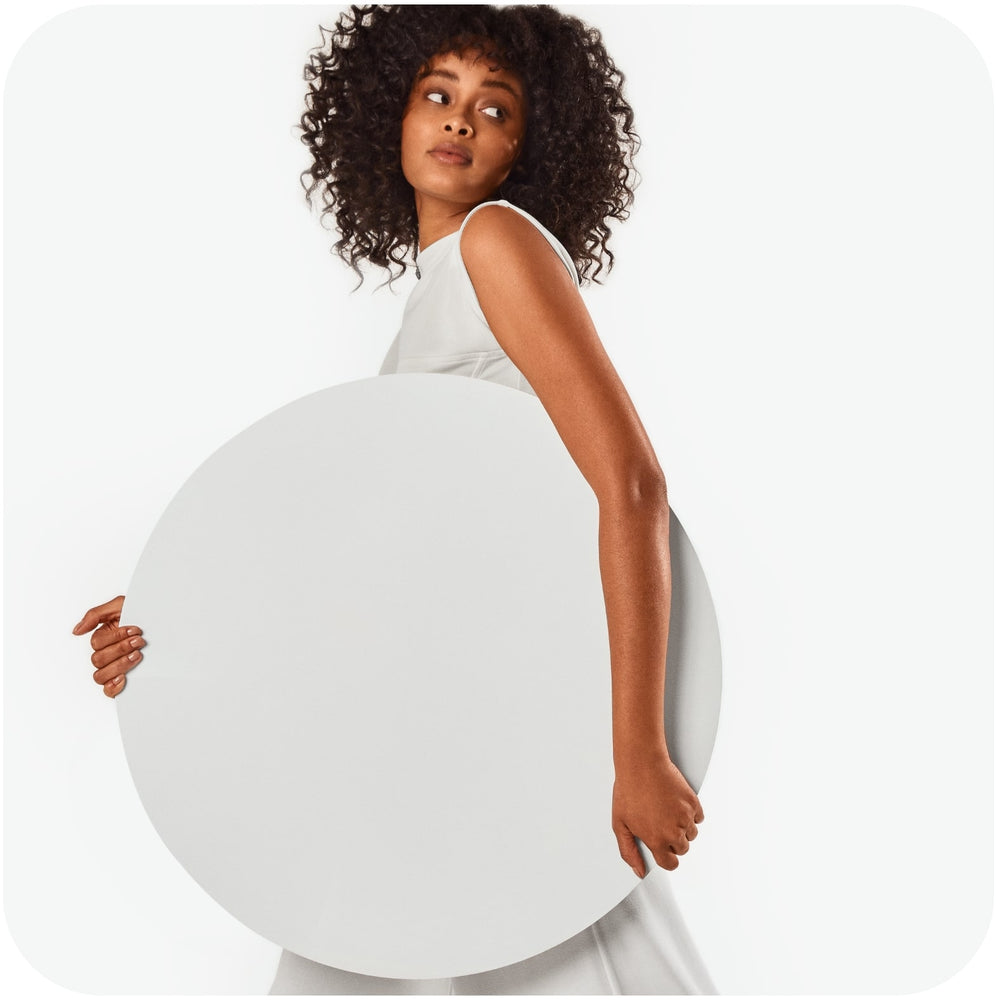 15 Best Ingredients for Oily Hair Conditioner Elegant woman holding a big round white thick paper symbolizing Bars Over Bottles oily hair conditioner