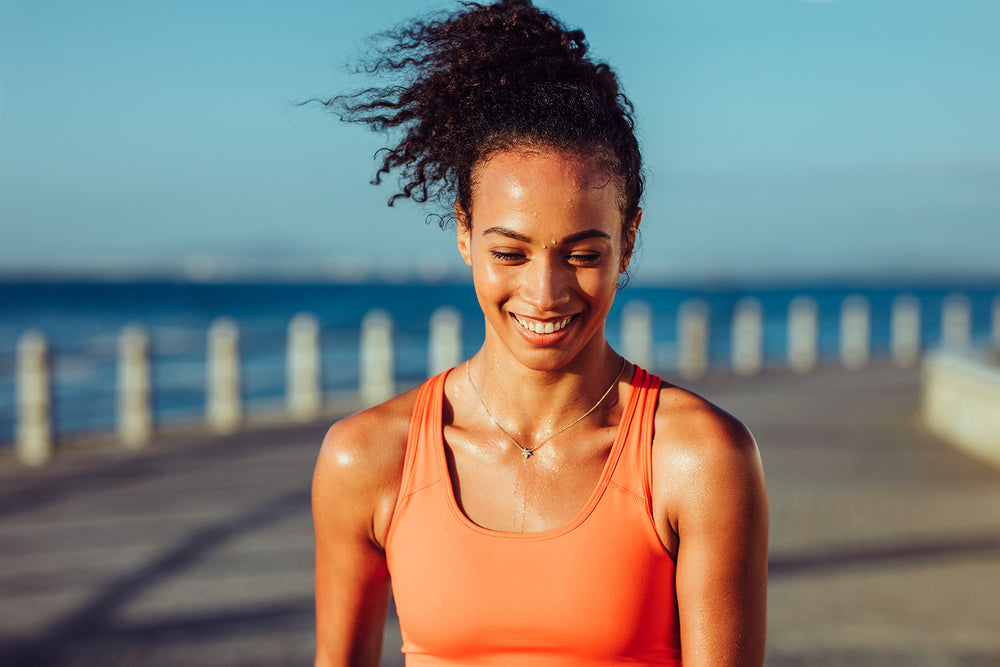 Did you know that sweating is essential for your armpits?!? Woman in an orange tank top sweating while running early morning