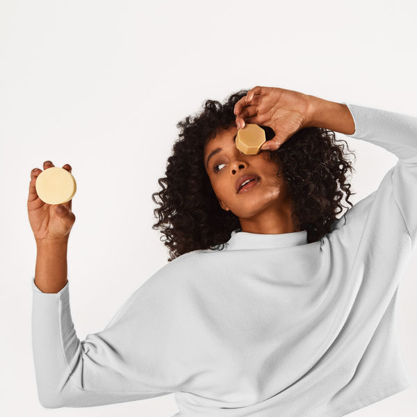 Girl holding the Curl Definer Conditioner Bar and Curl Defining Hair Mask