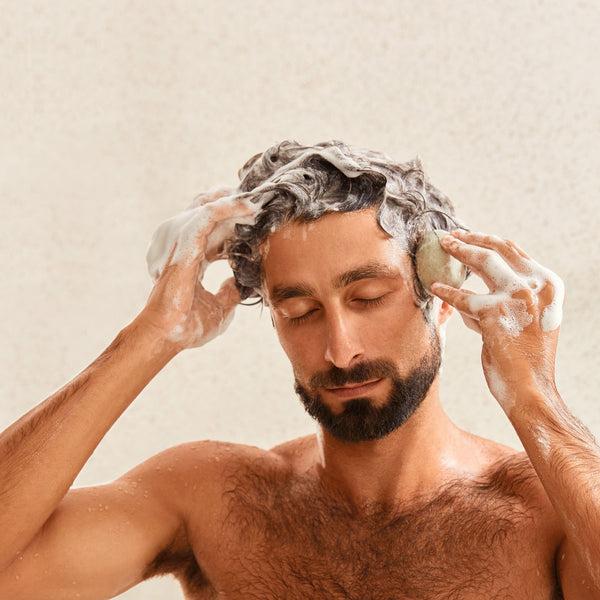 Man applying shampoo bar