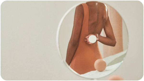Woman in dark orange backless dress holding a Bars Over Bottles conditioner she bought after discovering the benefits of conditioner bar vs liquid